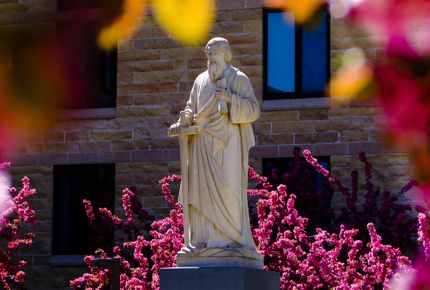 Pink blossoms fill the courtyard of the St. Paul Seminary and School of Divinity and surround a statue of St. Paul May 2, 2016.
