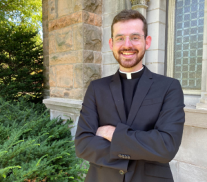 seminarian john utecht poses in front of st. paul seminary's chapel