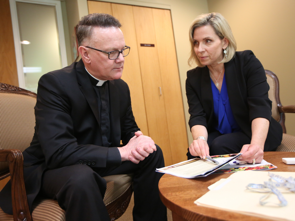 Susan Torborg speaks with a priest