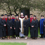 saint paul seminary lay student graduates pose outside in the seminary courtyard