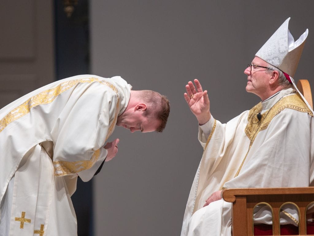 bishop robert barron blesses deacon josh miller before he preaches the Gospel at The Saint Paul Seminary