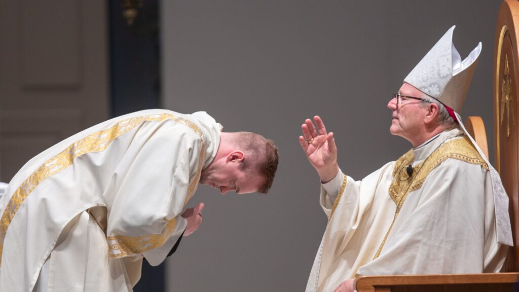 bishop robert barron blesses then-deacon josh miller before he reads the Gospel at Mass at The Saint Paul Seminary