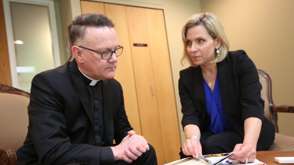saint paul seminary health and wellness coordinator Susan Torborg meets with a Catholic priest