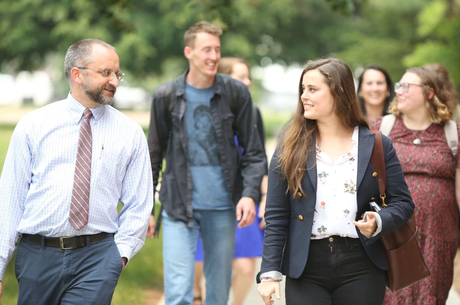 lay students walking and talking with a professor at the saint paul seminary