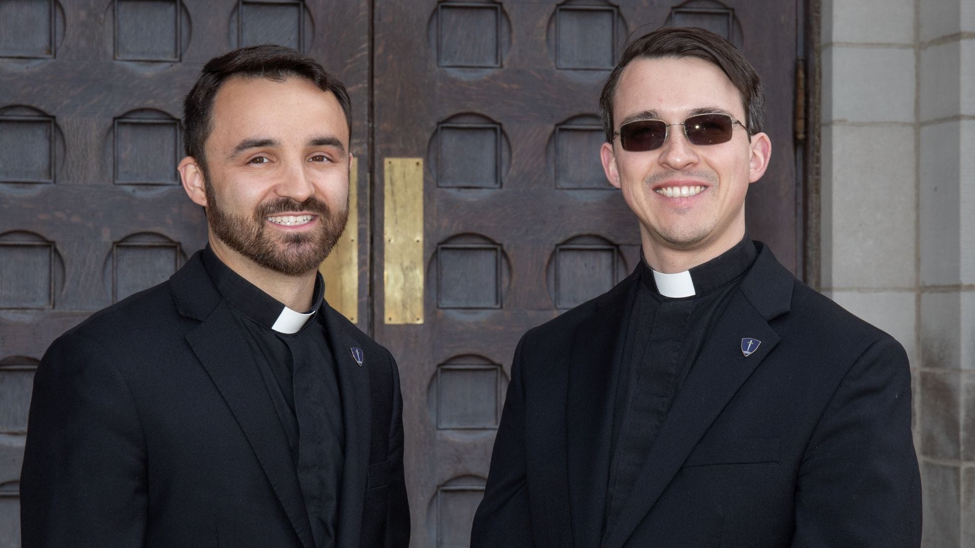 Two seminarians standing by each other and smiling