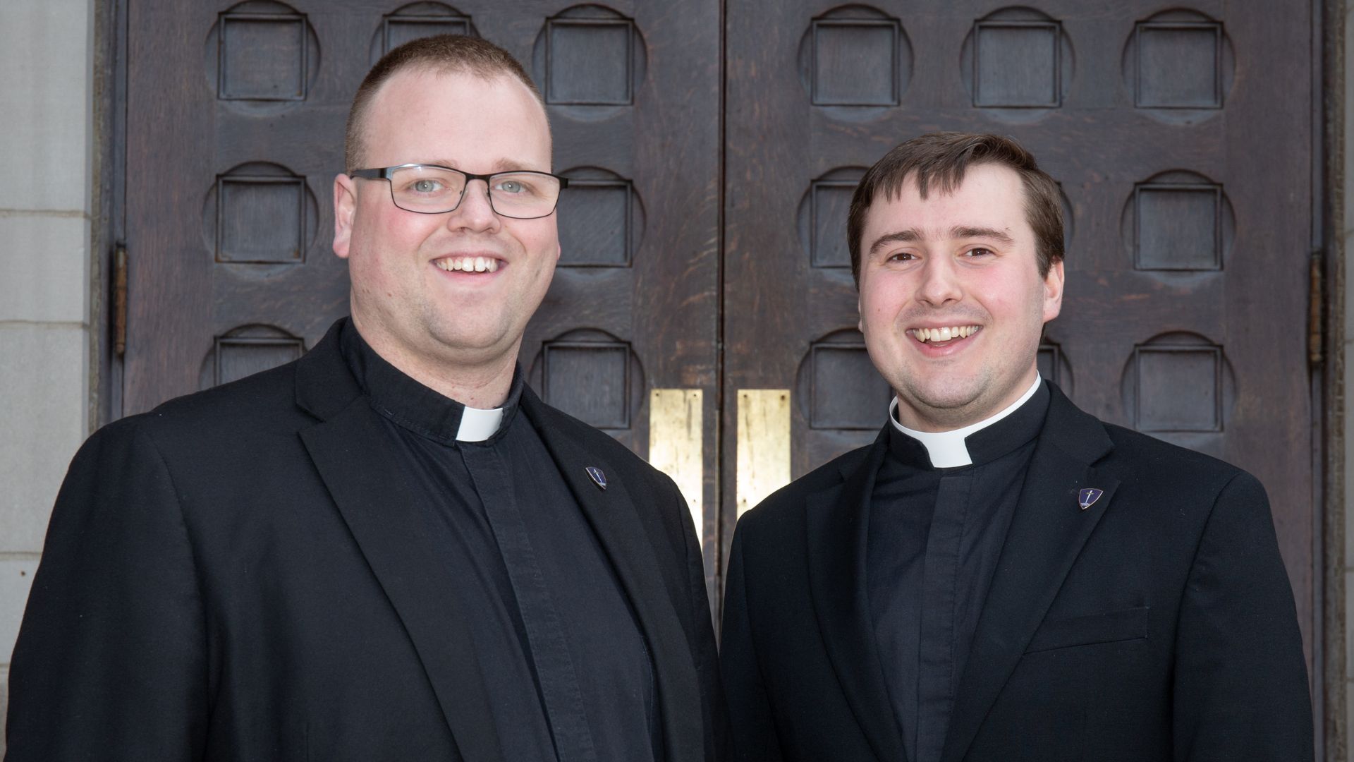 Two seminarians standing aside one another