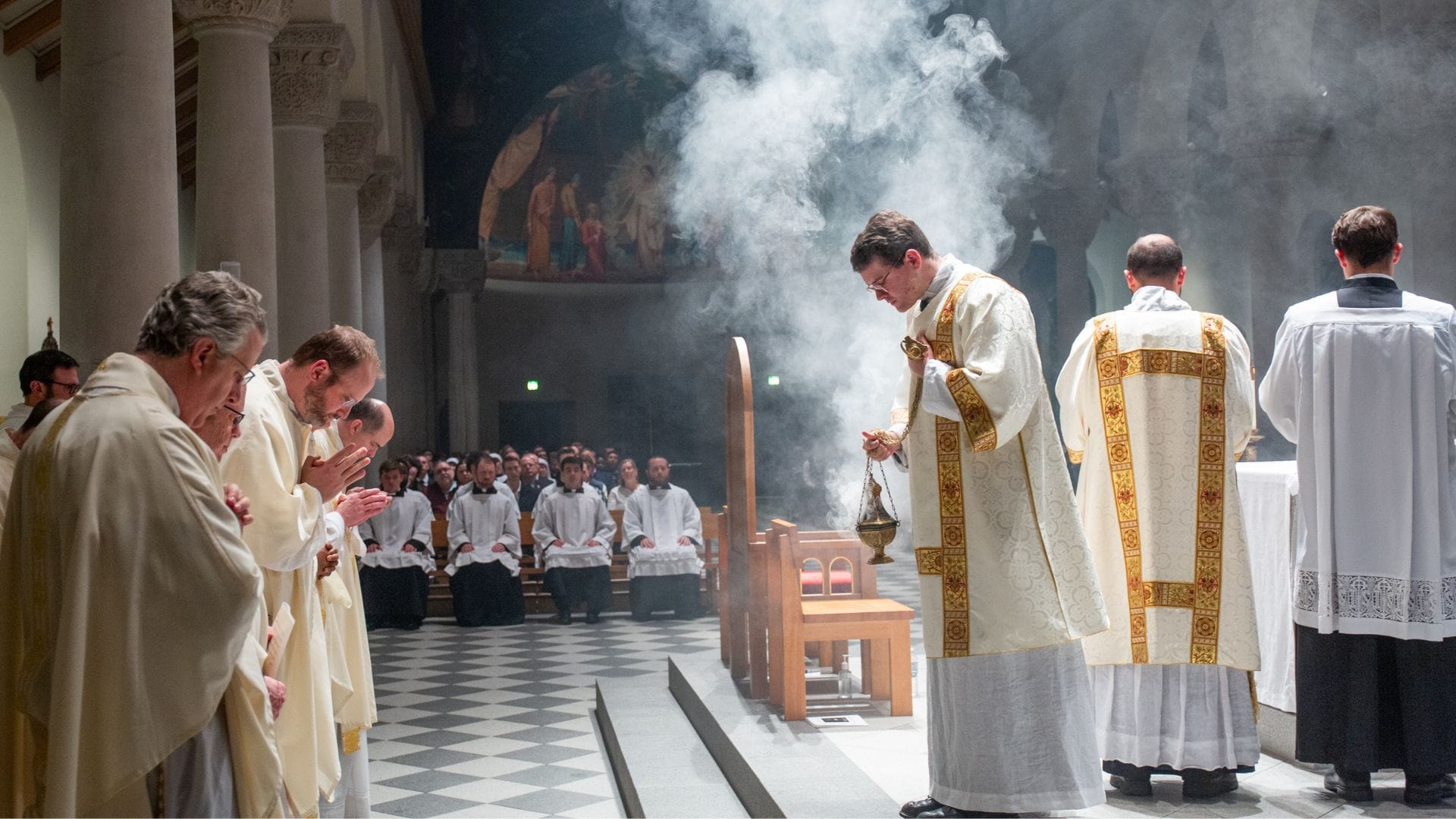 Deacon incenses the priests at Holy Mass