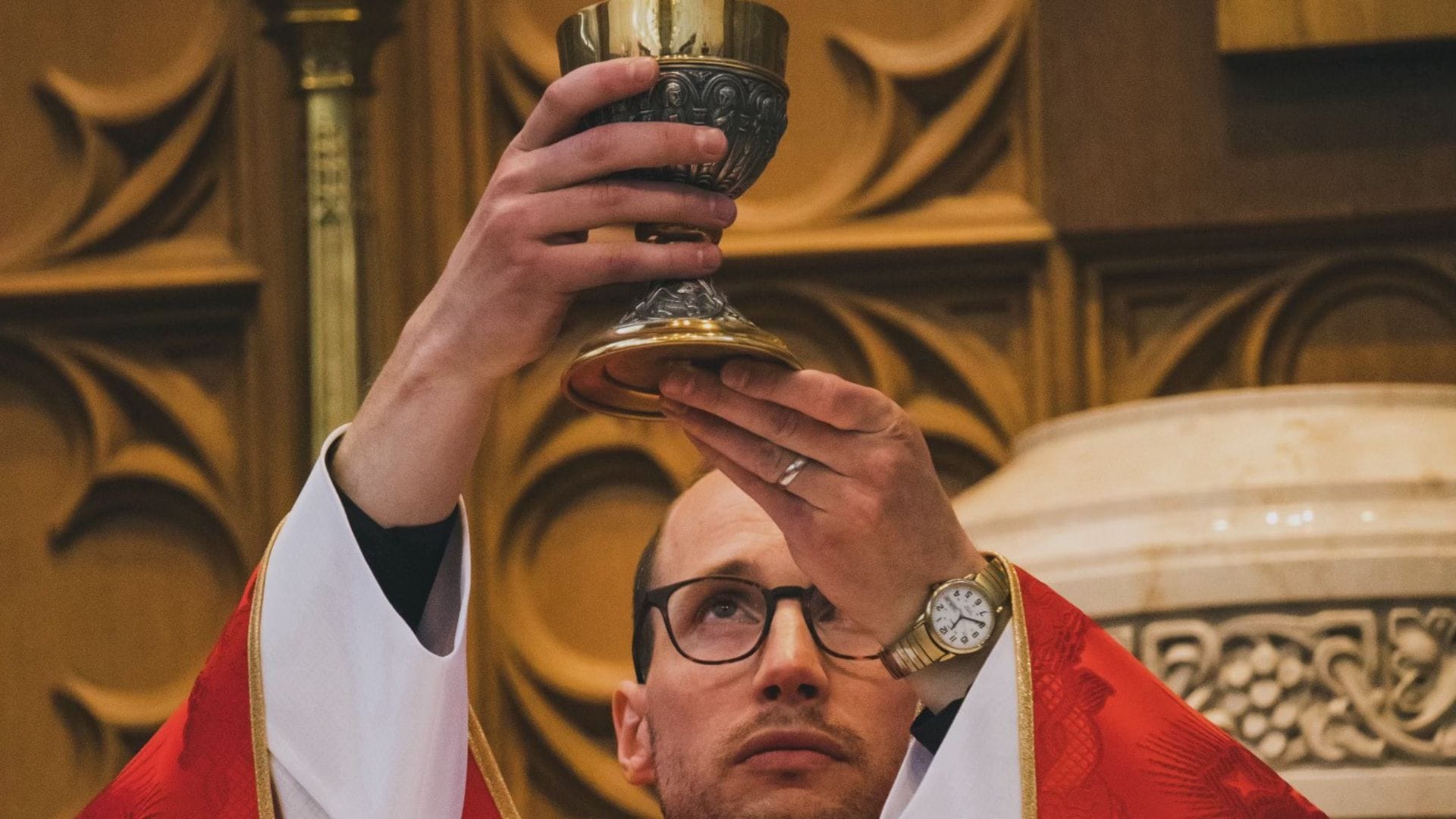 Priest holds up the chalice during the consecration