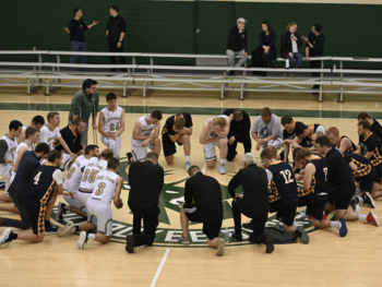 seminarians praying at center court at the 2024 de sales invitational basketball tournament